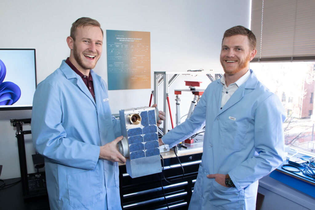 Katalyst engineers show off a small satellite.