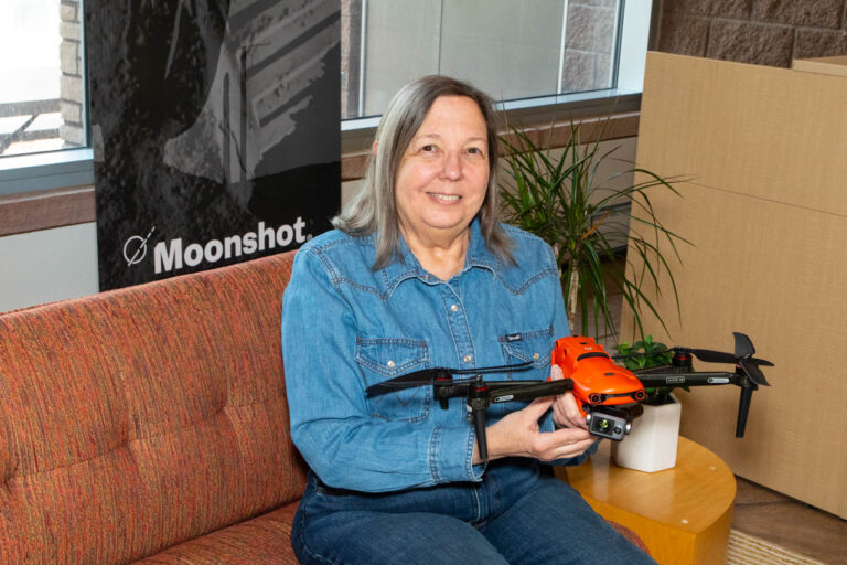 Ariel Strong of FireFlight holding her fire science drone.